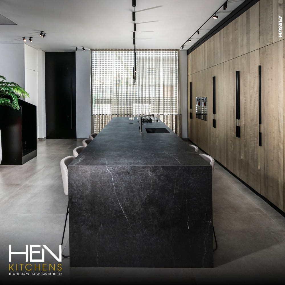 מטבח יוקרתי עם אי שיש שחור ענק וארונות עץ - HEN KITCHENS